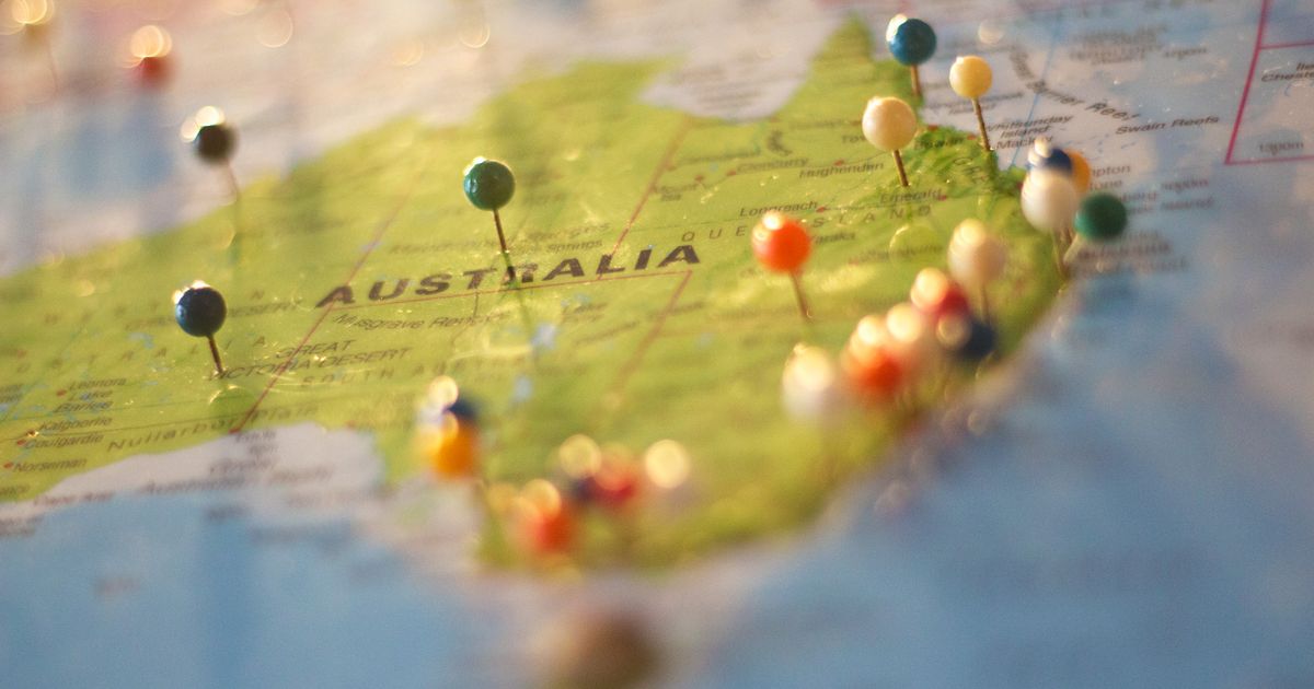 Close-up of a map of Australia with colorful pins marking various cities and destinations.