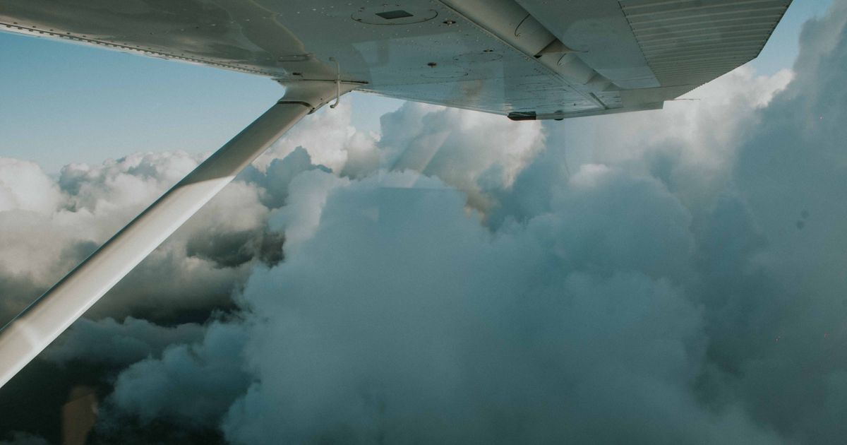 A serene view of dense clouds from an airplane wing, capturing the essence of flight and exploration.