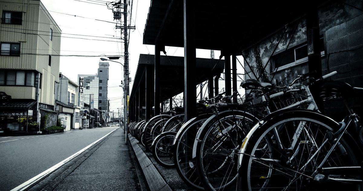 A row of parked bicycles along an urban street, showcasing city life and transportation.