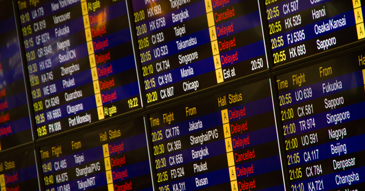 Close-up of digital flight information board showing arrivals and departures at an airport.