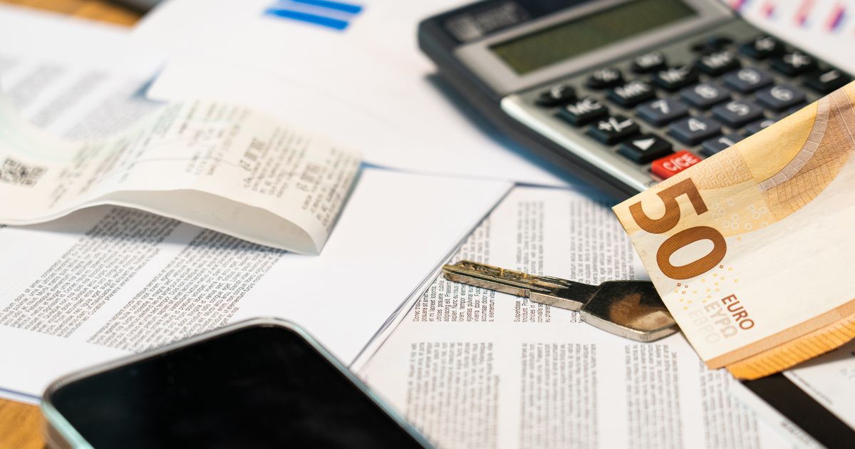 Flat lay of financial documents, euro note, calculator, smartphone, and key for budget management.