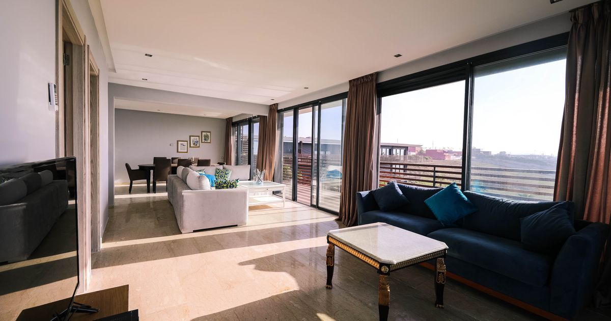 Bright and airy contemporary living room with furniture and large windows overlooking a city view.