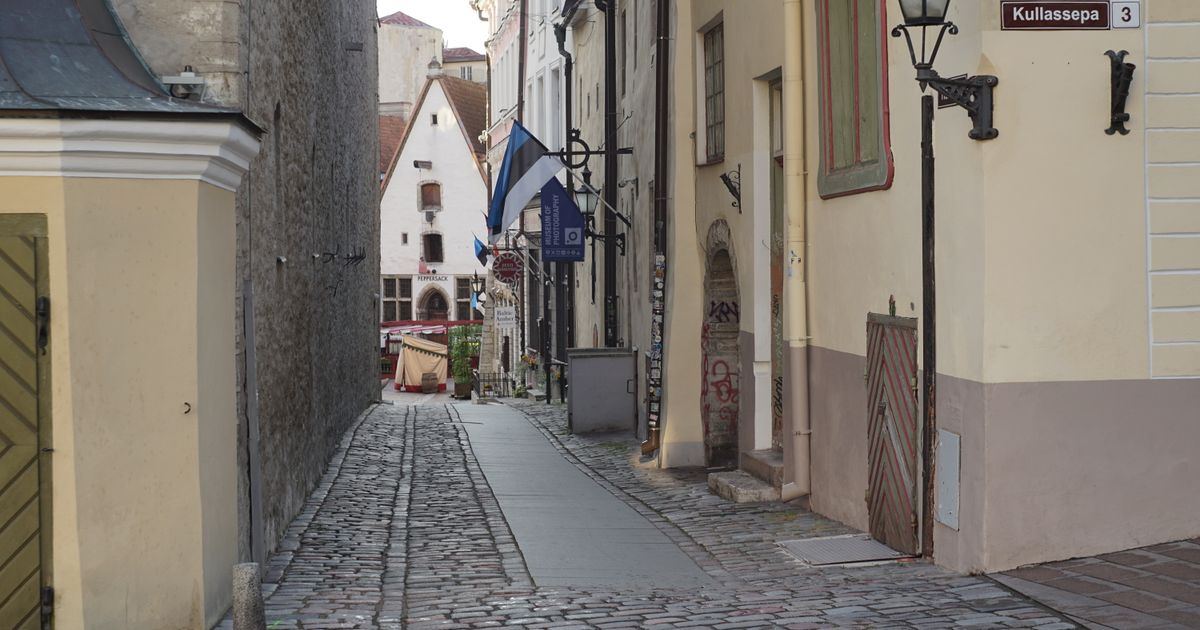 A picturesque view of a medieval street in Tallinn's Old Town, Estonia, showcasing cobblestones and historic buildings.